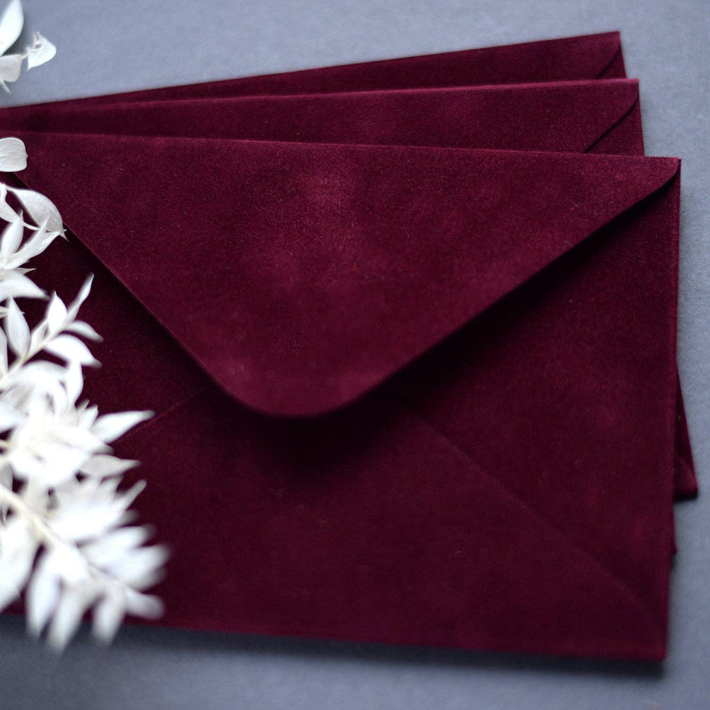 Close-up of wine red velvet paper envelopes with elegant stationery
