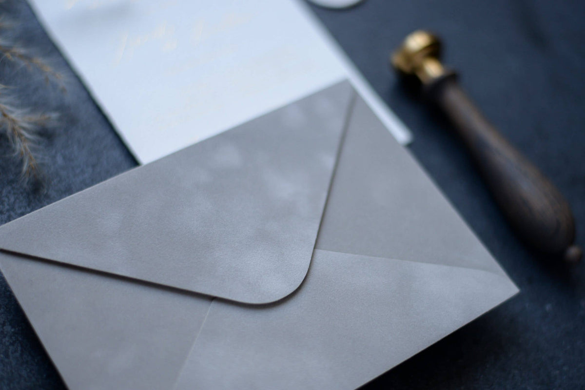 Close-up of a light grey velvet paper envelope with elegant stationery