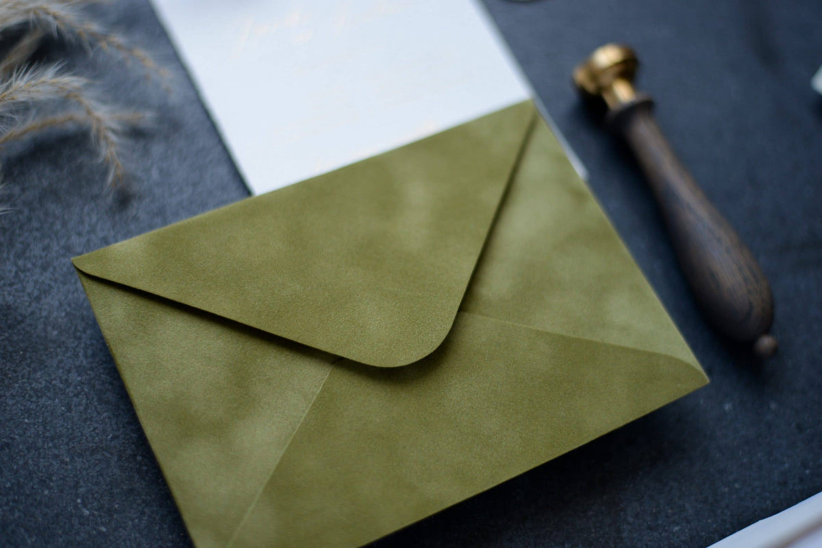 Close-up of an olive green velvet paper envelope showing its soft textured surface
